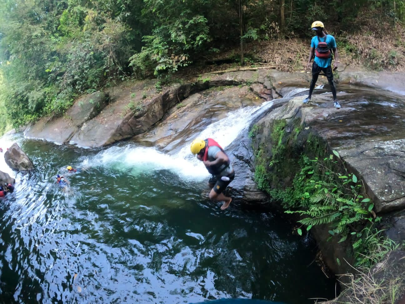 Tourist sliding down the natural rock water slides in the canyon