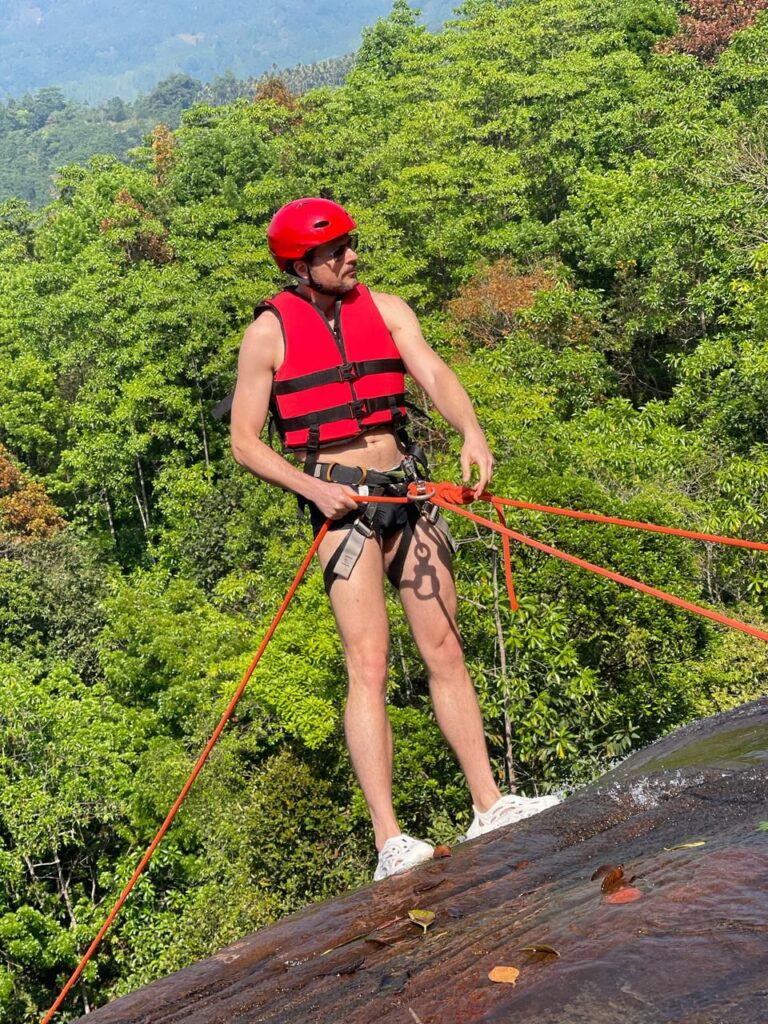 Abseiling down Sandun Ella waterfall with safety ropes