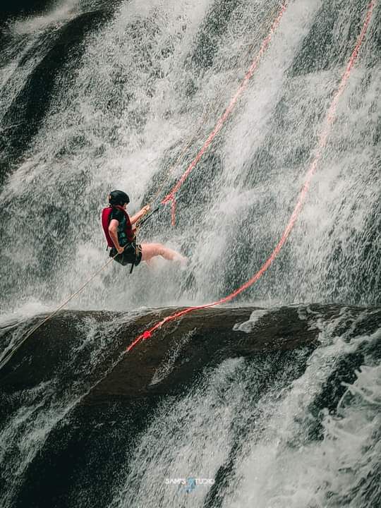 Abseiling down Sandun Ella waterfall with safety ropes
