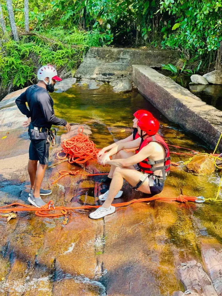 Abseiling down Sandun Ella waterfall with safety ropes